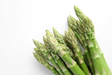 Photo of Fresh green asparagus stems on white table, top view. Space for text