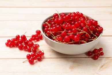 Photo of Fresh red currant berries in bowl on white wooden table