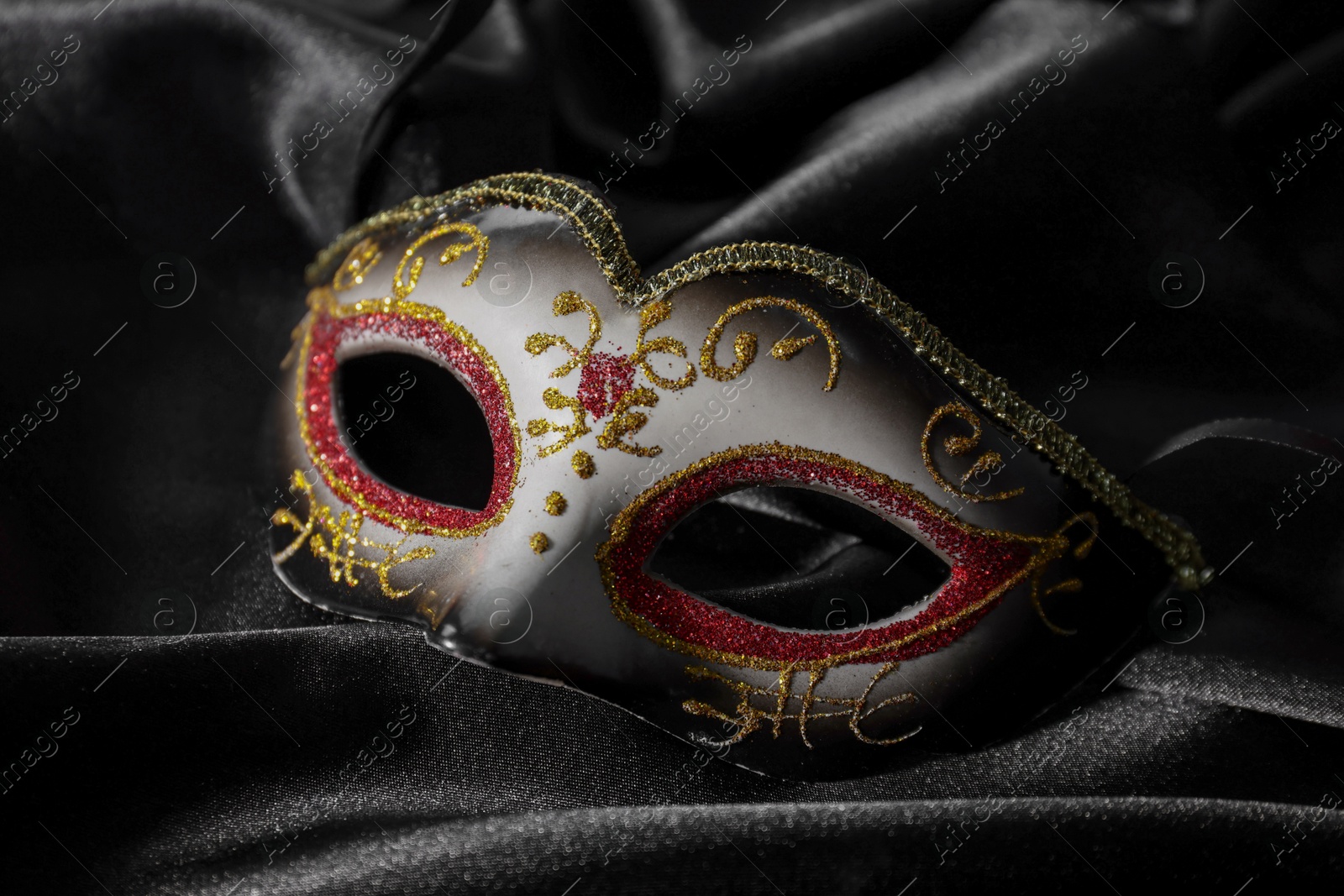 Photo of One beautiful carnival mask on black fabric