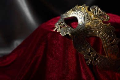 One beautiful carnival mask on red fabric, closeup