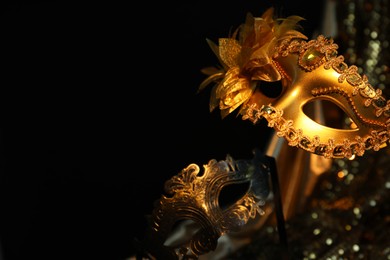 Photo of Beautiful carnival mask in darkness, closeup. Space for text