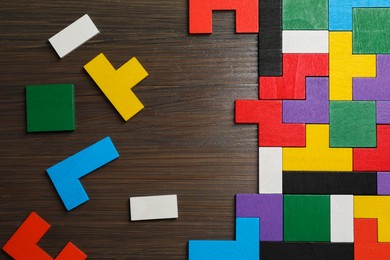 Photo of Colorful puzzle pieces on wooden table, top view