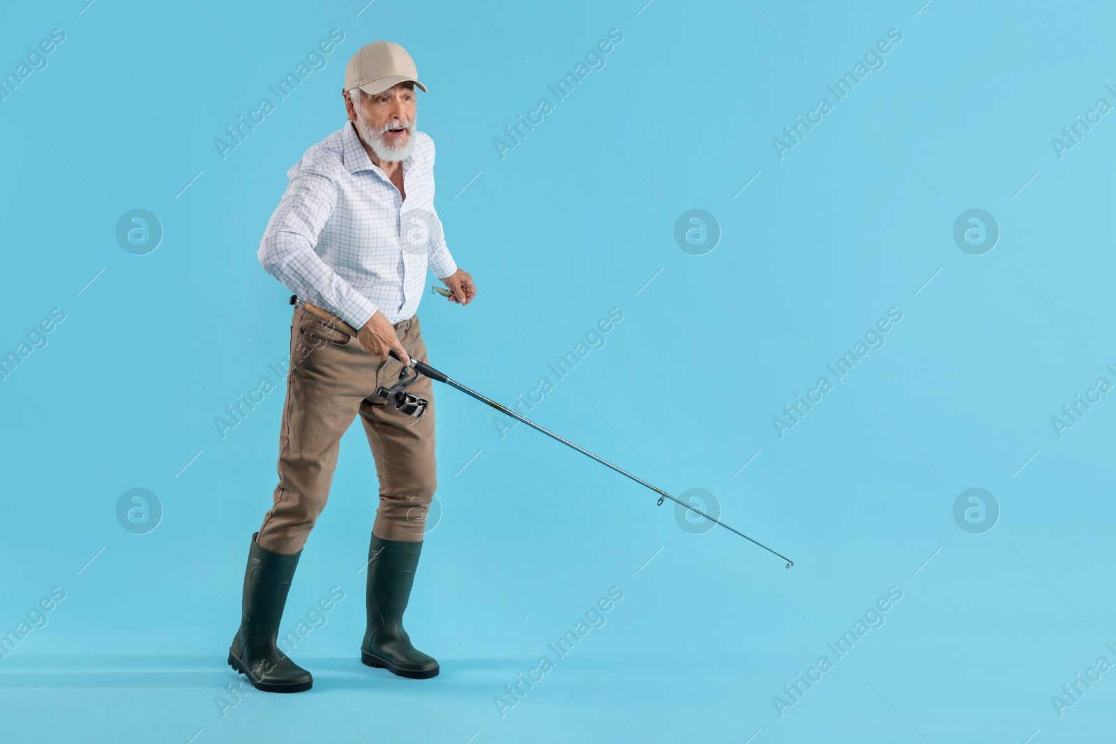 Photo of Fisherman with rod on light blue background