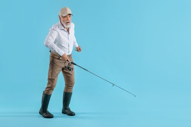 Photo of Fisherman with rod on light blue background