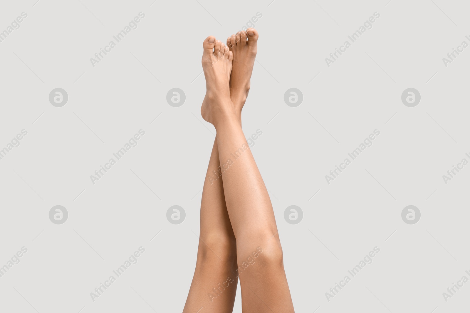 Photo of Woman with smooth legs on grey background, closeup