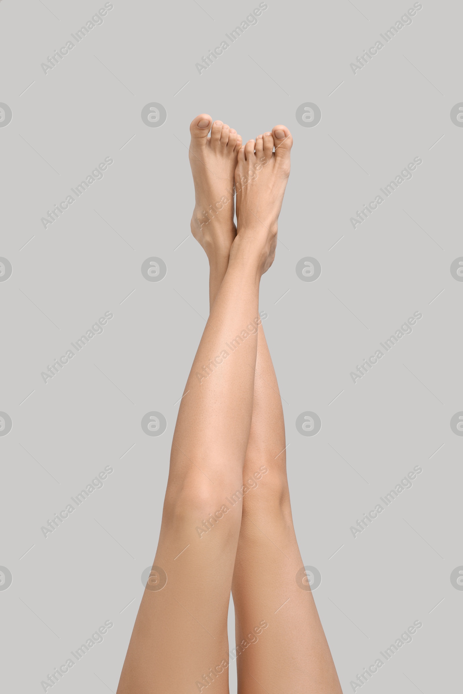 Photo of Woman with smooth legs on grey background, closeup