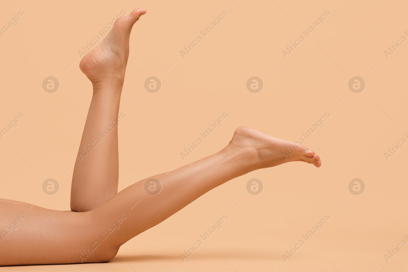 Photo of Woman with smooth legs on beige background, closeup