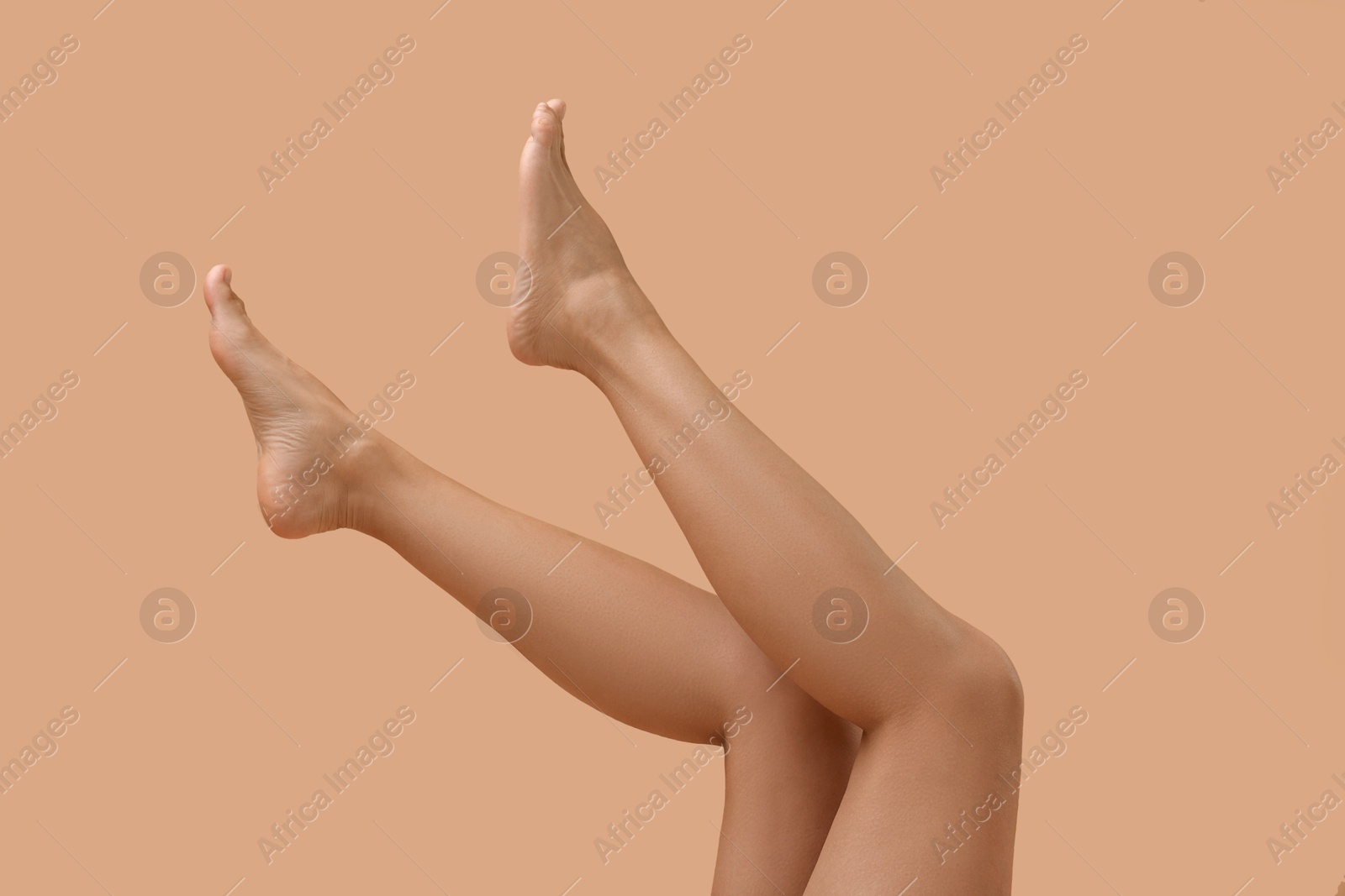 Photo of Woman with smooth legs on beige background, closeup