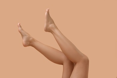 Photo of Woman with smooth legs on beige background, closeup