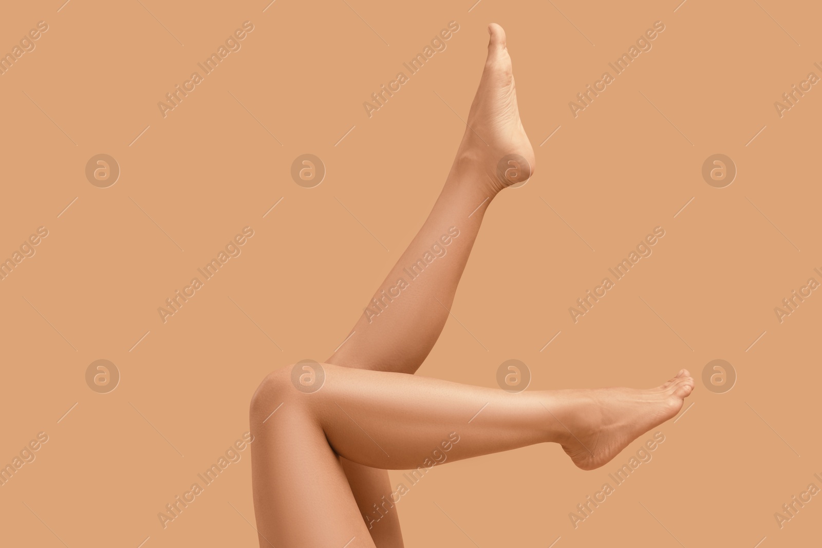 Woman with smooth legs on beige background, closeup Photo of Woman with smooth legs on beige background, closeup