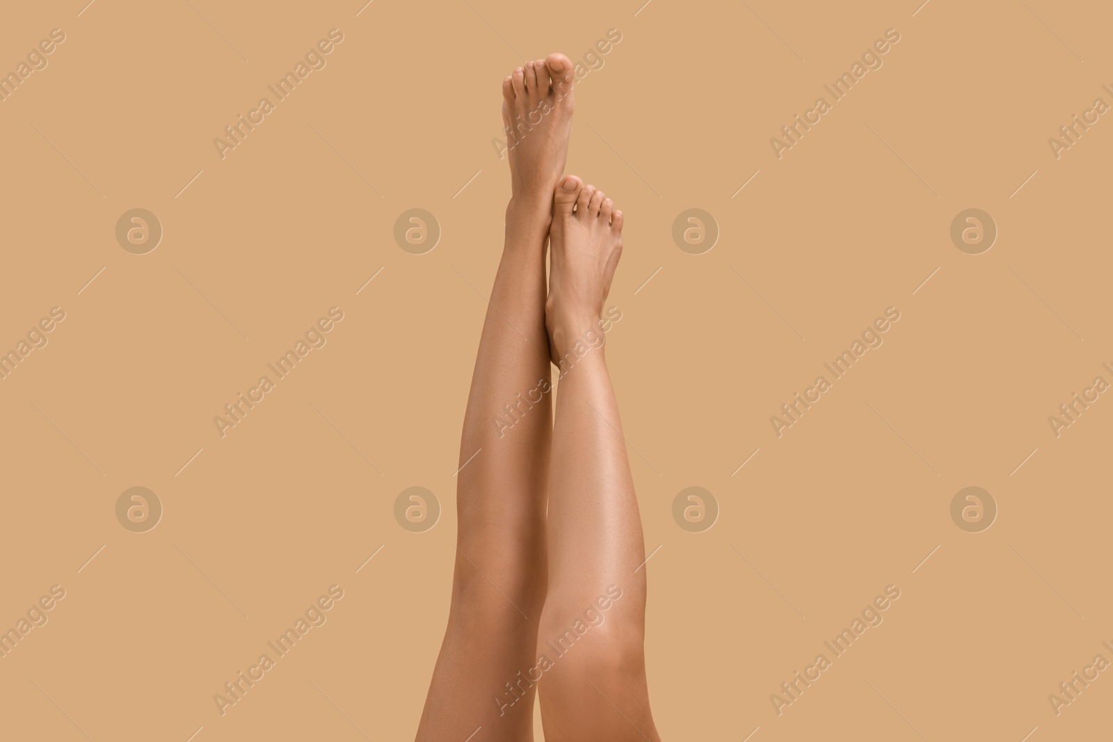 Photo of Woman with smooth legs on beige background, closeup