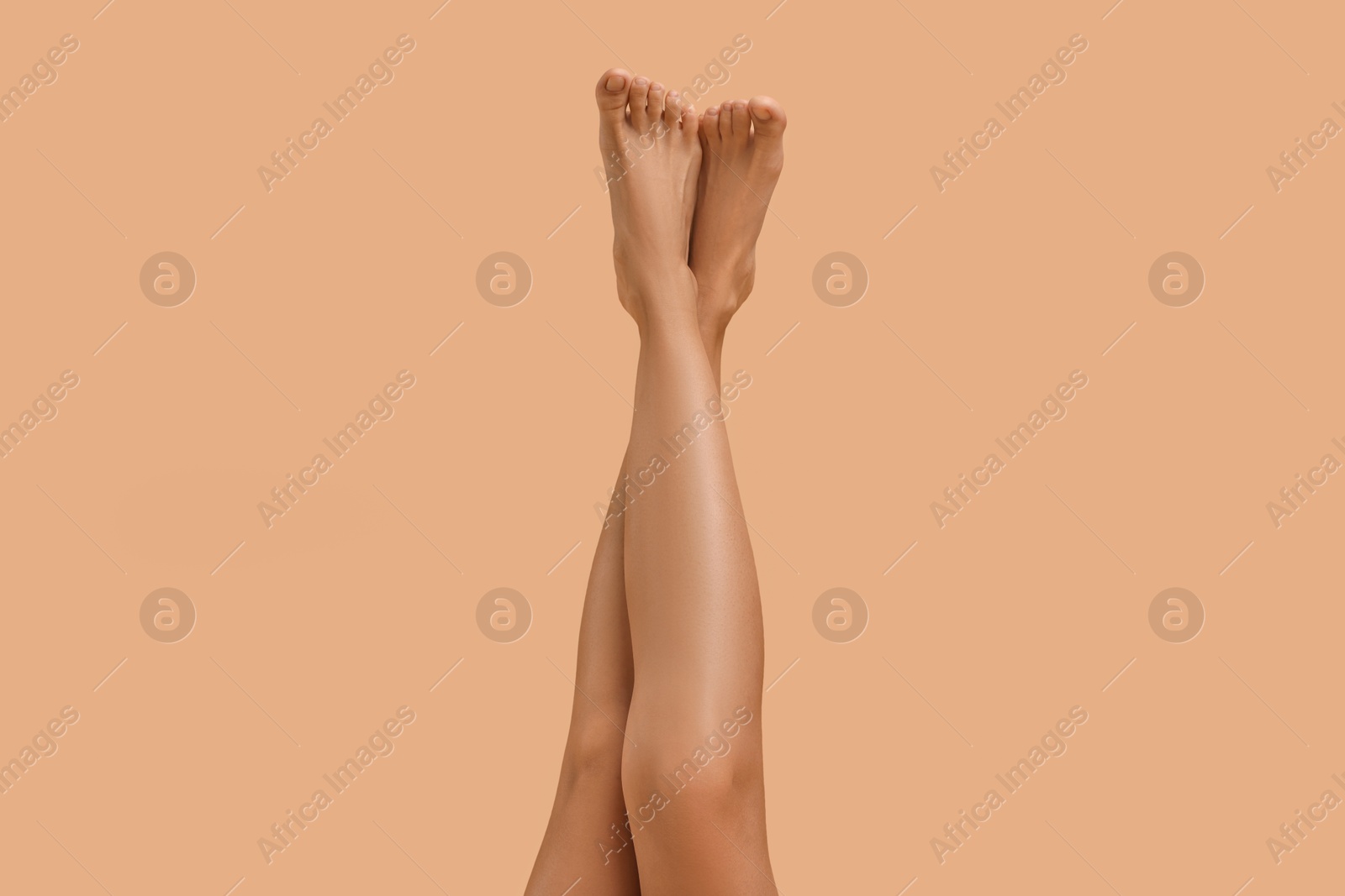 Photo of Woman with smooth legs on beige background, closeup