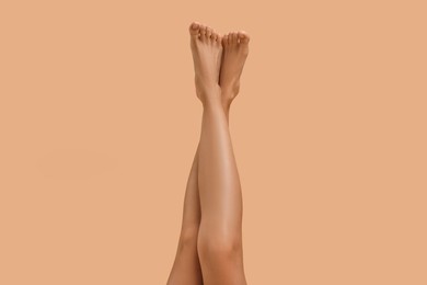 Photo of Woman with smooth legs on beige background, closeup