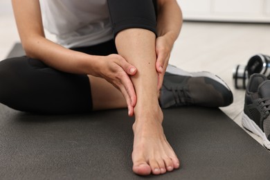 Photo of Woman suffering from foot pain at home, closeup