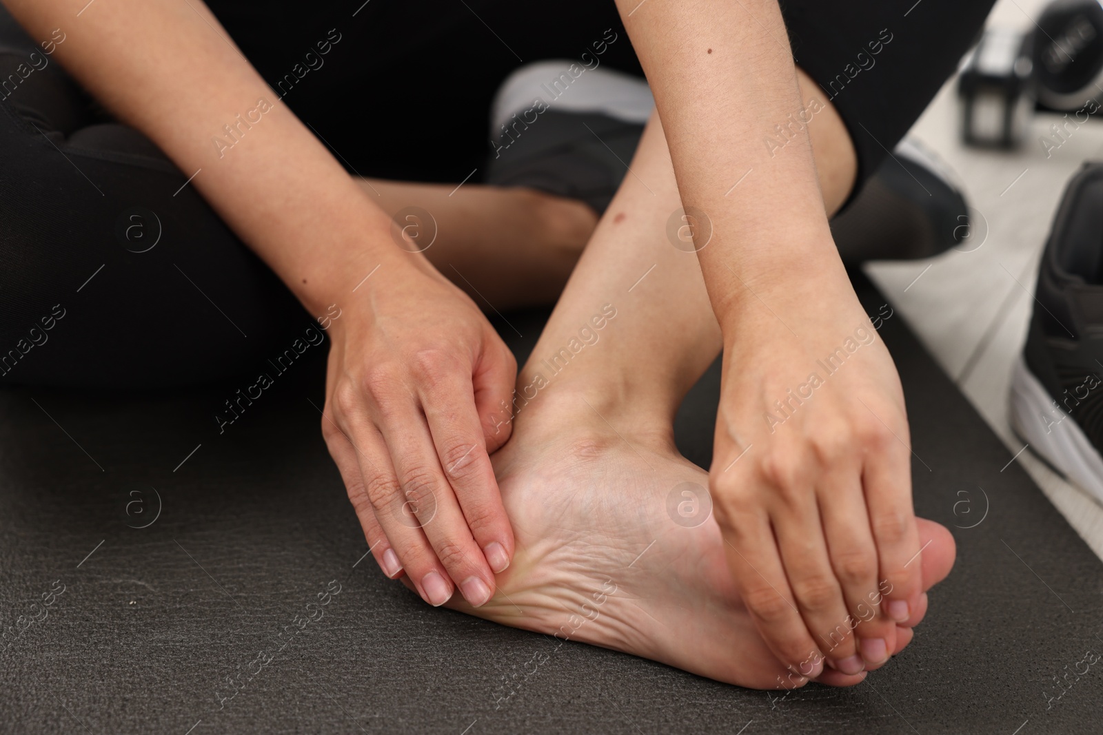 Photo of Woman suffering from foot pain at home, closeup