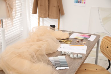 Photo of Fashion designer`s workplace with fabric samples and sewing supplies