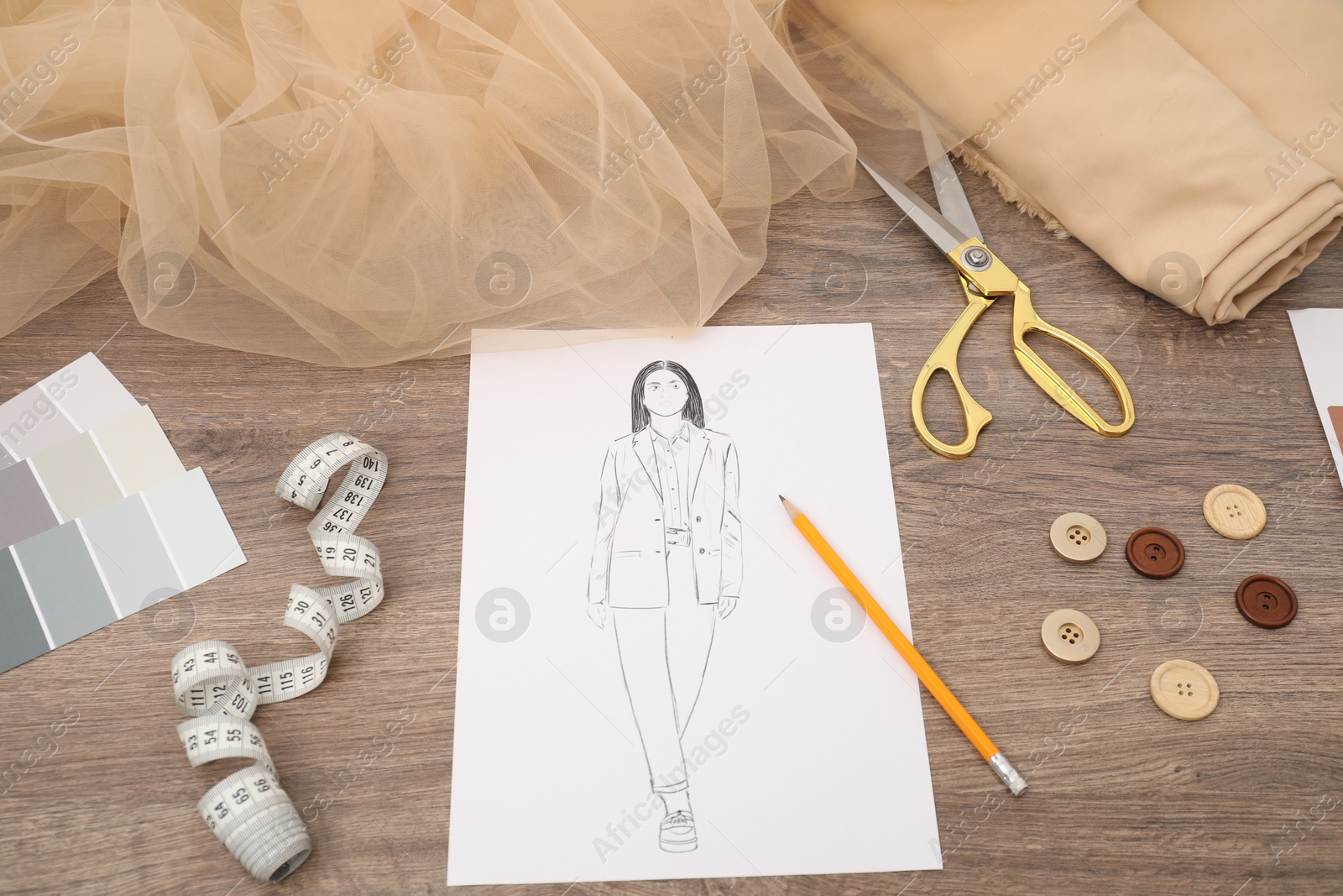 Photo of Sketch of stylish clothes, color palette and other fashion designer`s supplies on wooden table