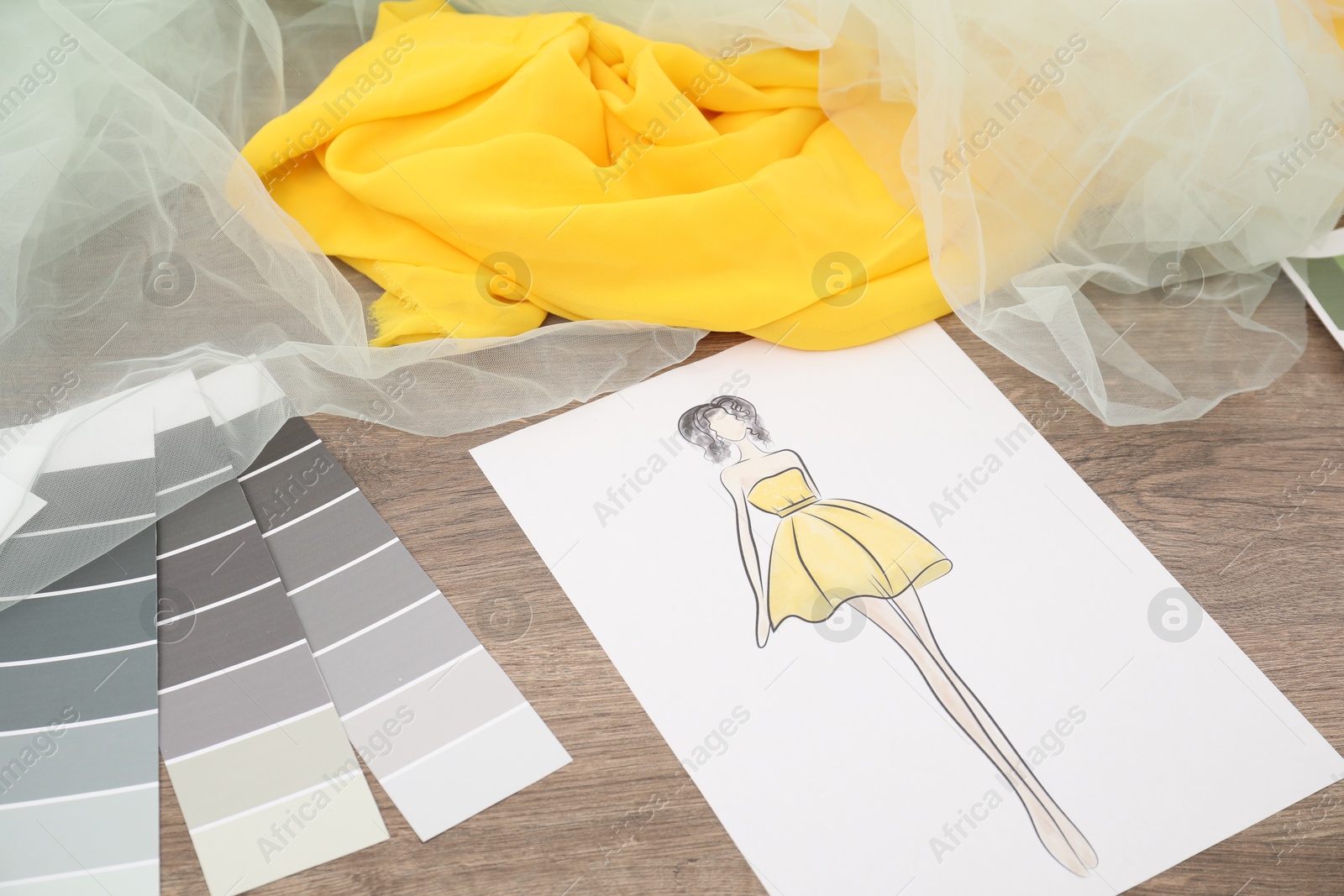 Photo of Sketch of stylish clothes, color palette and other fashion designer`s supplies on wooden table