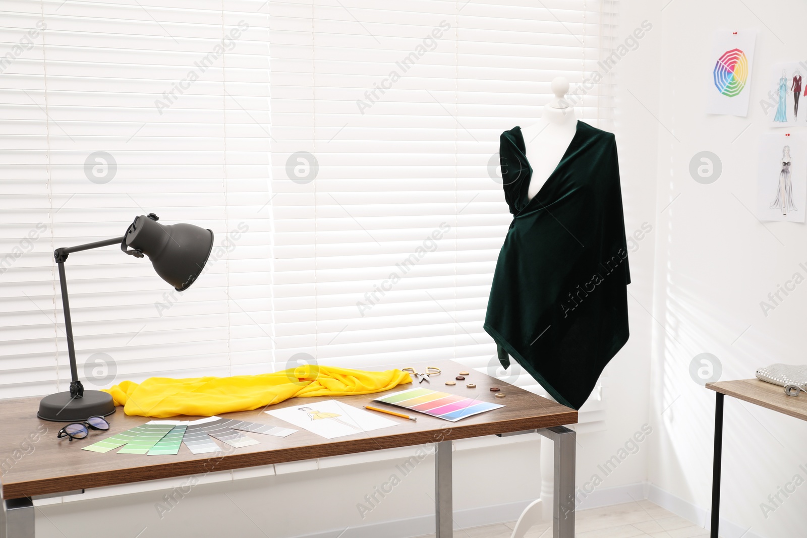 Photo of Fashion designer`s workplace with color palette, fabric samples and sewing supplies