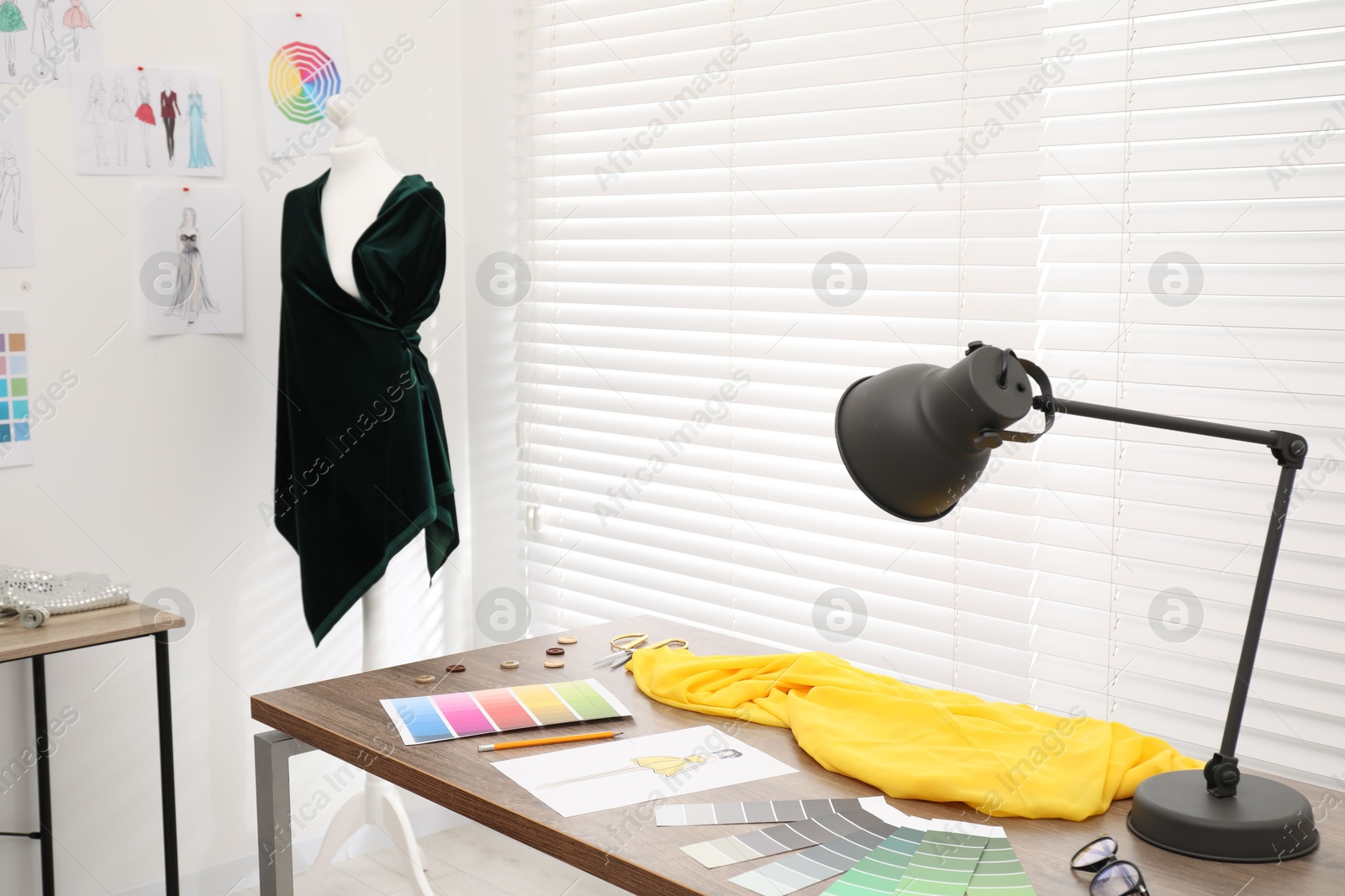 Photo of Fashion designer`s workplace with color palette, fabric samples and sewing supplies