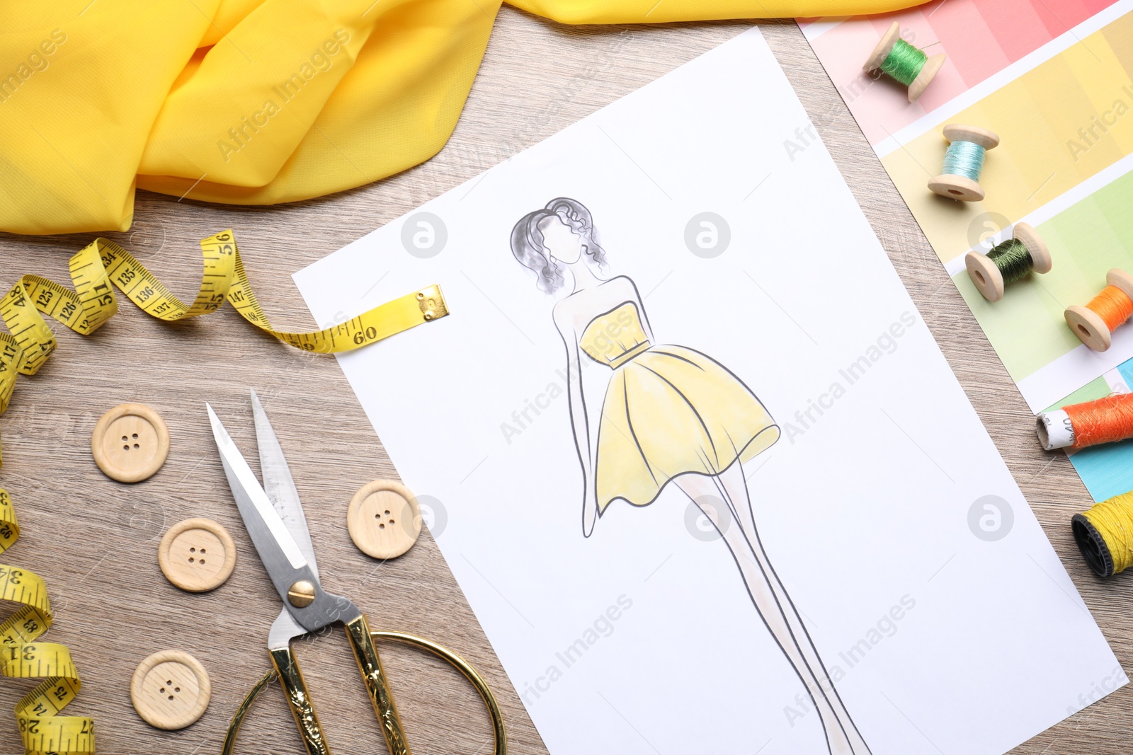 Photo of Sketch of stylish clothes and other fashion designer`s supplies on wooden table, flat lay