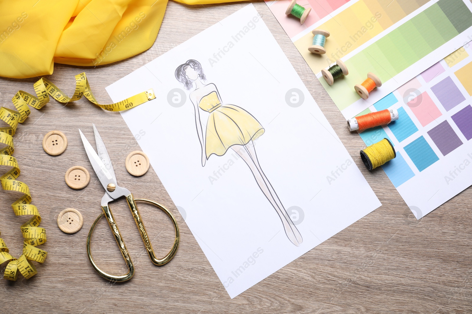 Photo of Sketch of stylish clothes and other fashion designer`s supplies on wooden table, flat lay