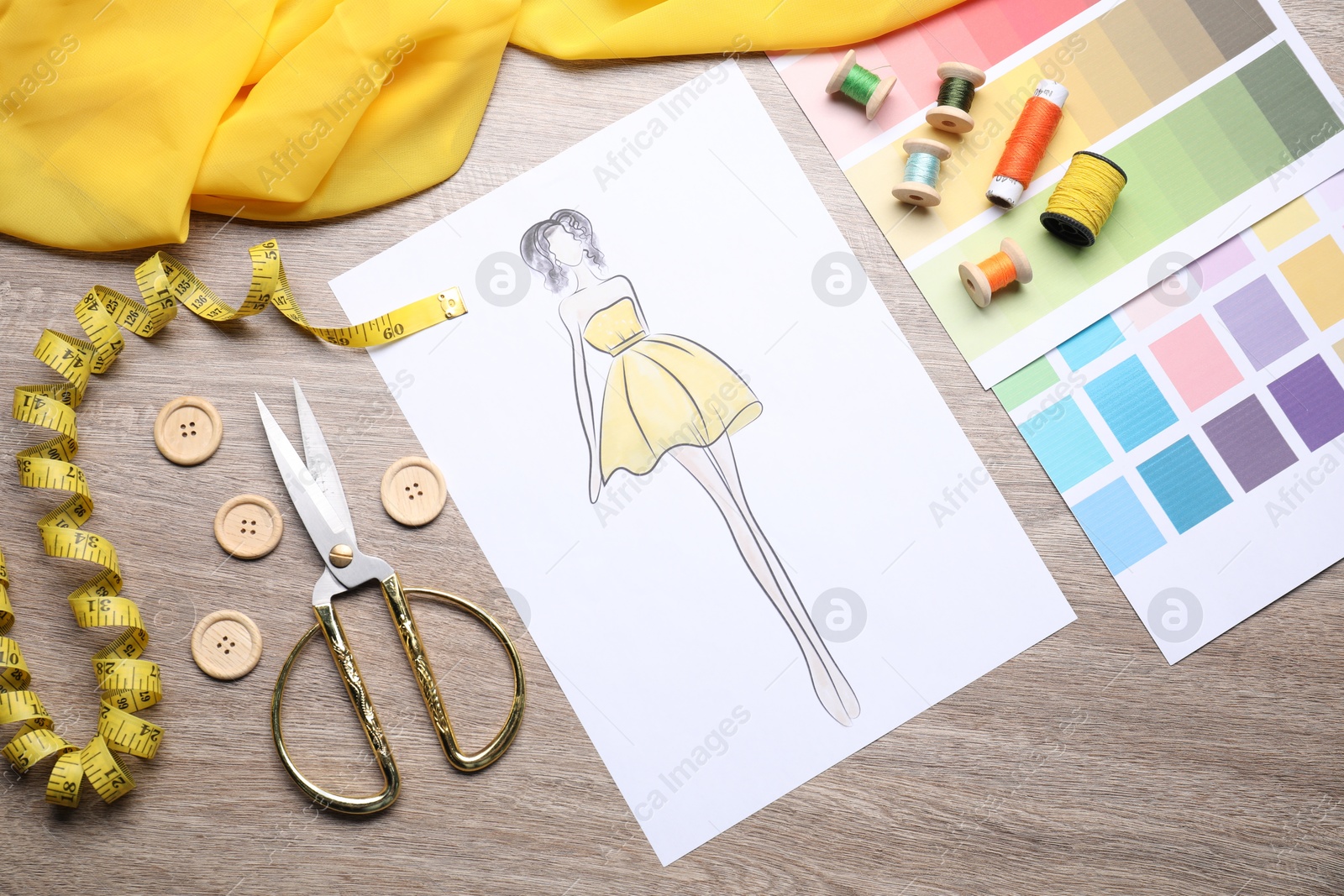 Photo of Sketch of stylish clothes and other fashion designer`s supplies on wooden table, flat lay