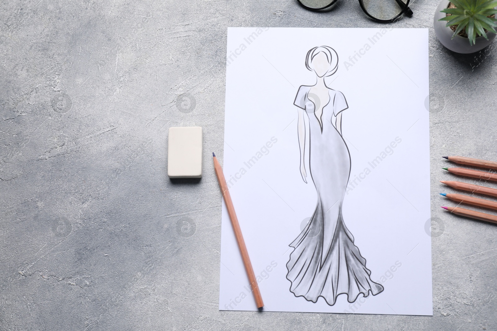 Photo of Sketch of stylish clothes and other fashion designer`s supplies on grey table, flat lay. Space for text