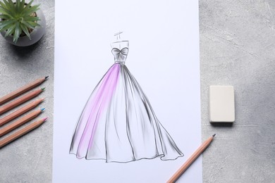 Photo of Sketch of stylish clothes and other fashion designer`s supplies on grey table, flat lay