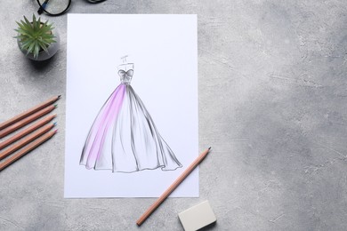 Photo of Sketch of stylish clothes and other fashion designer`s supplies on grey table, flat lay. Space for text