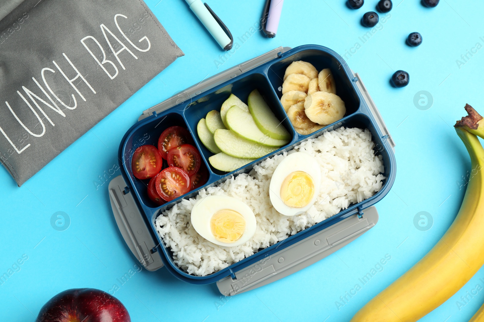 Photo of Bag, lunch box with snacks and pens on light blue background, flat lay