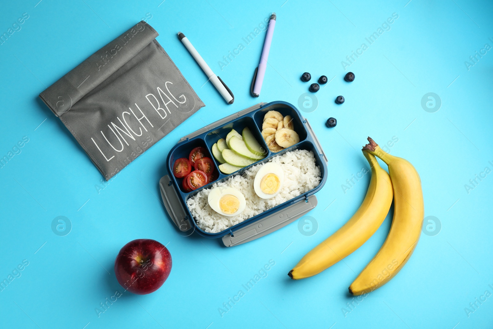 Photo of Bag, lunch box with snacks and pens on light blue background, flat lay