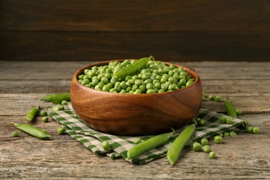 Photo of Fresh green peas and pods on wooden table