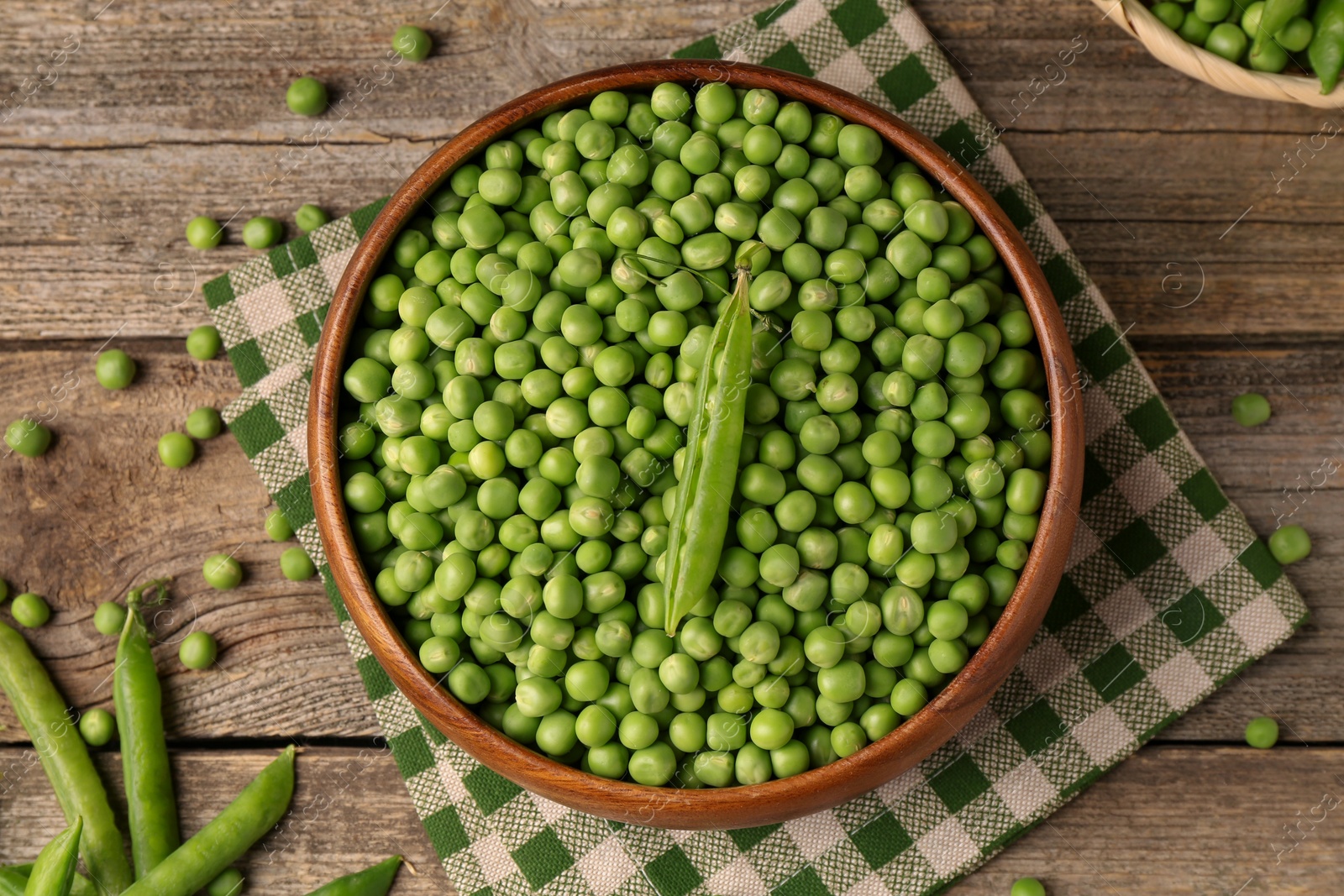 Photo of Fresh green peas and pods on wooden table, flat lay