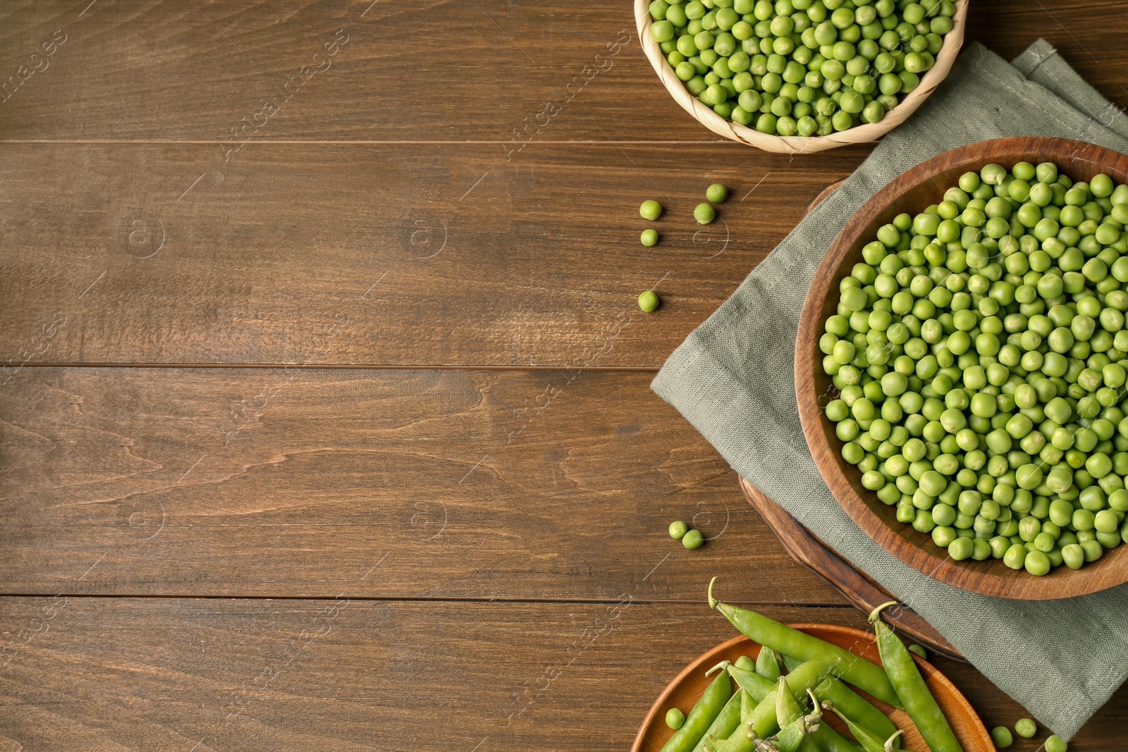 Photo of Fresh green peas and pods on wooden table, flat lay. Space for text