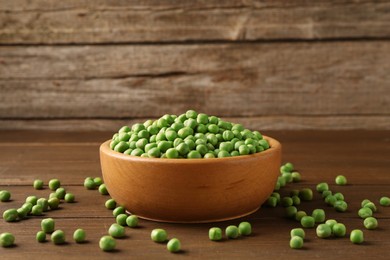 Photo of Fresh green peas in bowl on wooden table