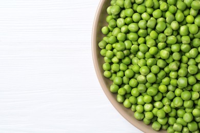 Photo of Fresh green peas on white wooden table, top view. Space for text