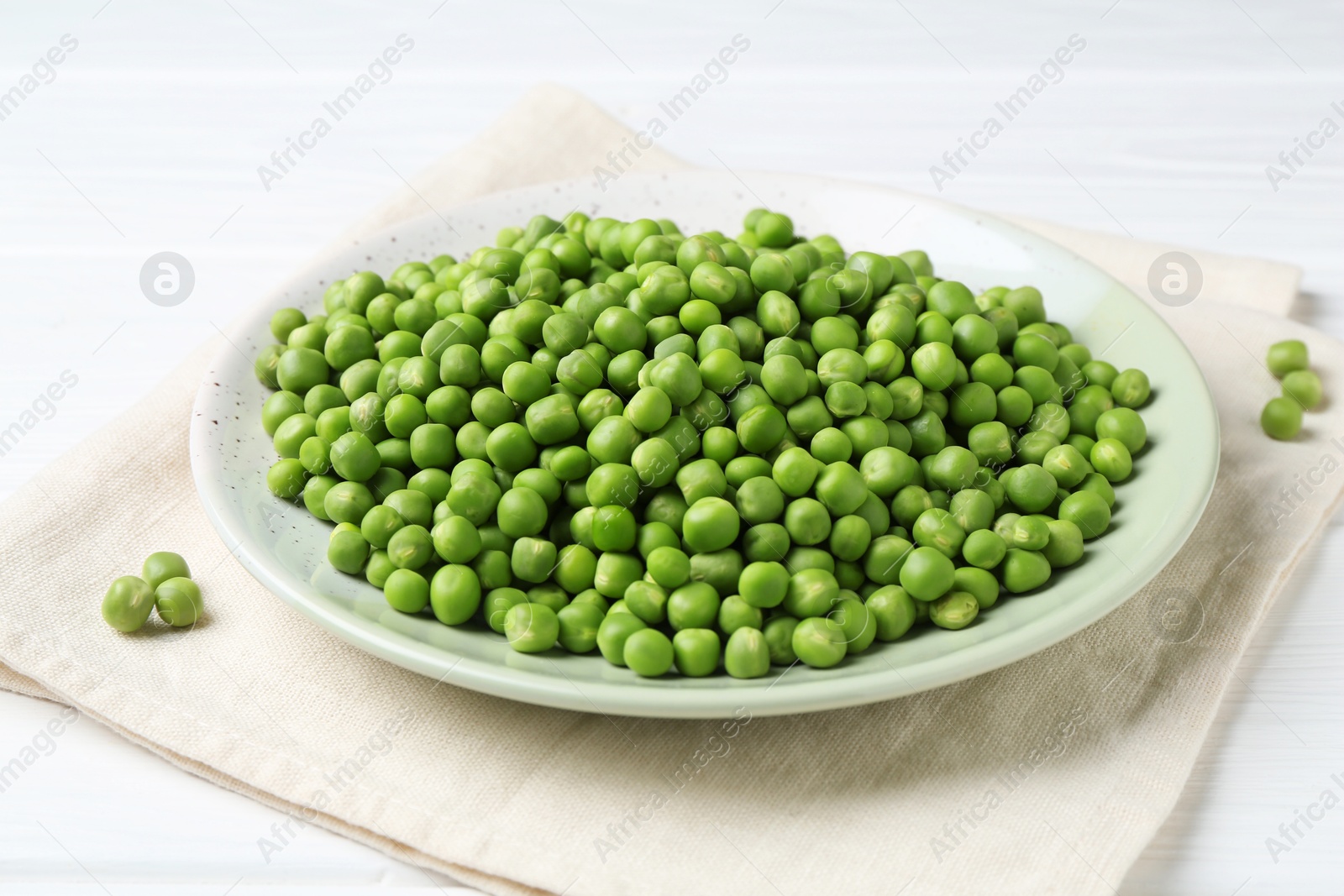 Photo of Fresh green peas on white wooden table