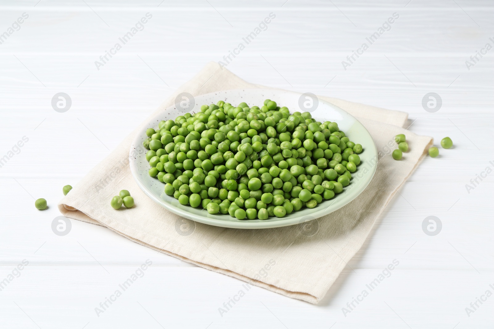 Photo of Fresh green peas on white wooden table