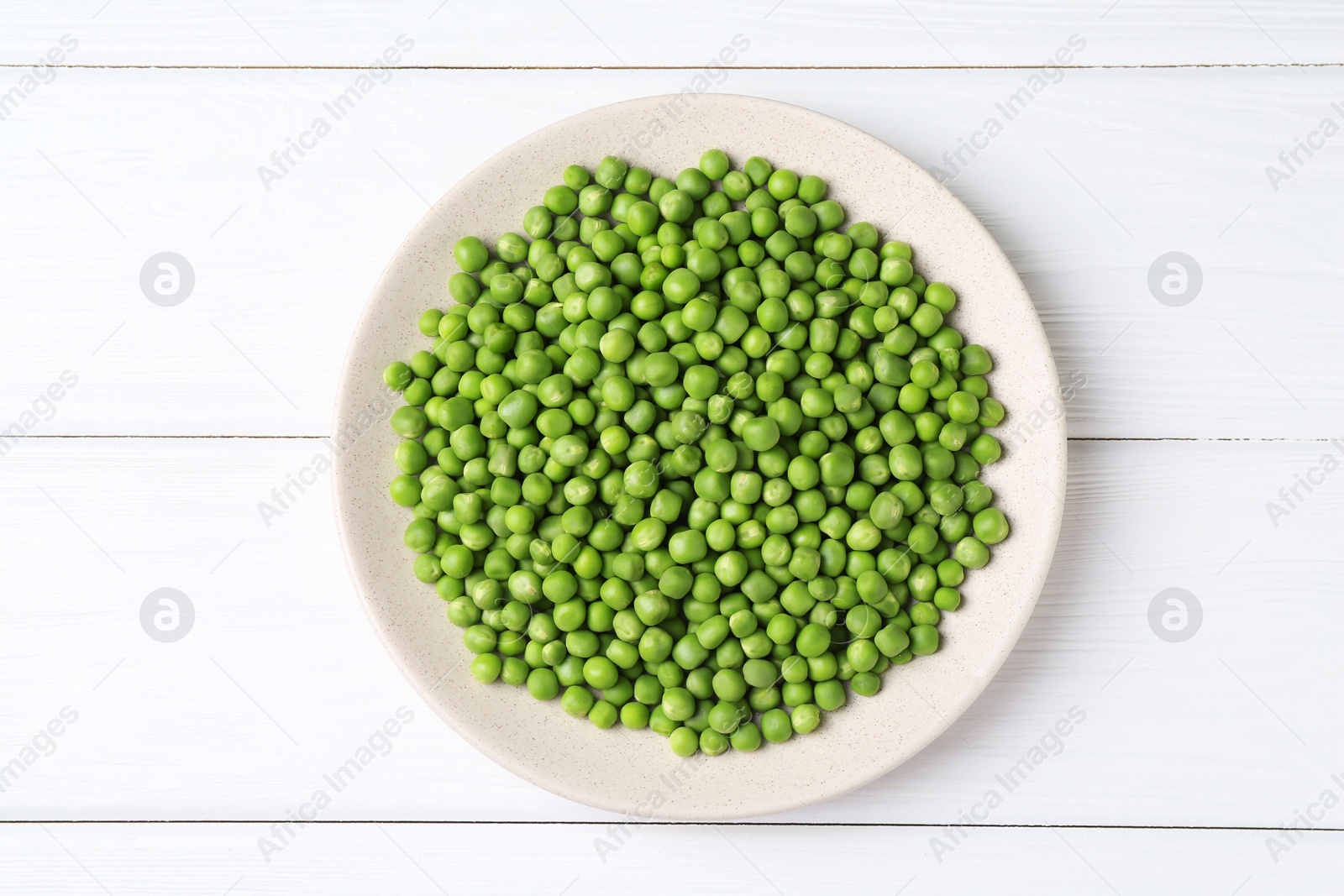 Photo of Fresh green peas on white wooden table, top view