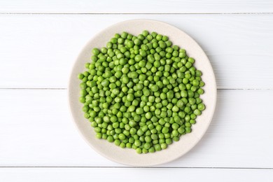 Fresh green peas on white wooden table, top view