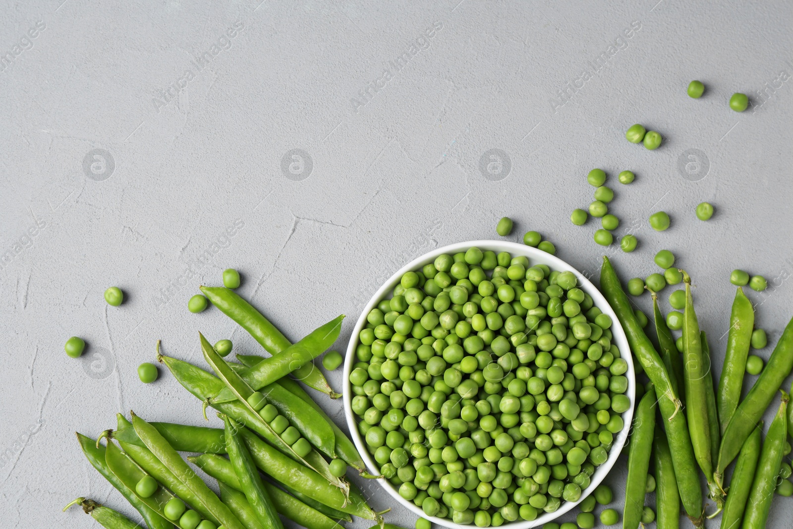 Photo of Fresh green peas and pods on grey table, flat lay. Space for text