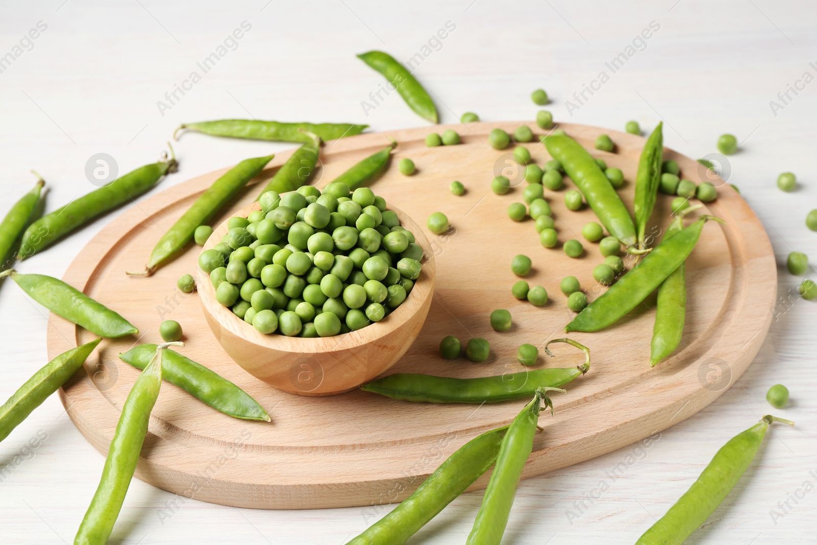 Photo of Fresh green peas and pods on white wooden table, closeup