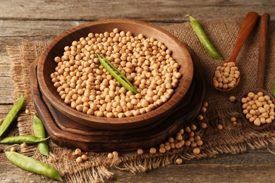 Photo of Fresh pods with peas and dried ones on wooden table, closeup