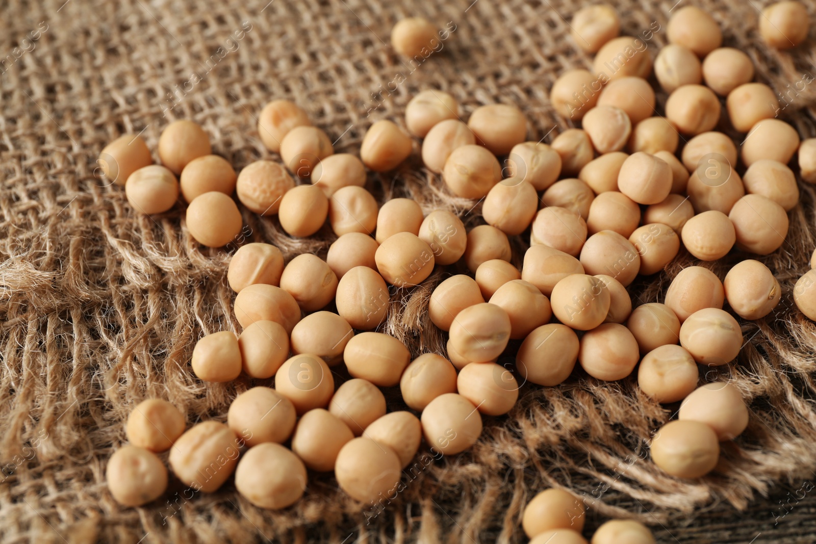 Photo of Many dried peas on burlap fabric, closeup