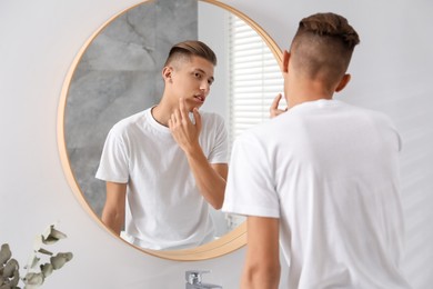 Man touching his face near mirror in bathroom