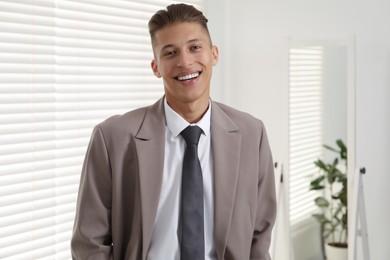 Handsome man in stylish suit at home