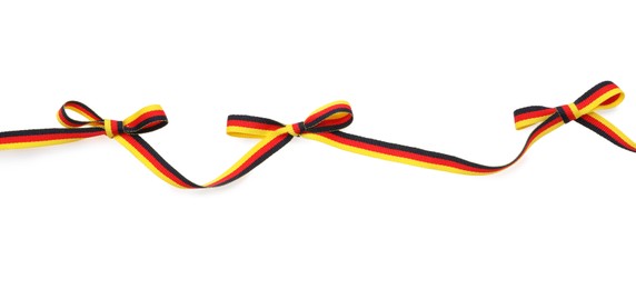 Photo of Ribbon with bows in colors of German flag isolated on white, top view