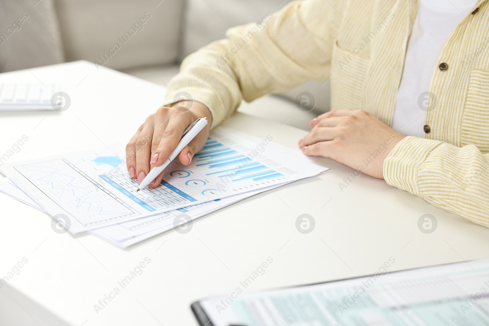 Photo of Budget planning. Woman with papers at white table, closeup