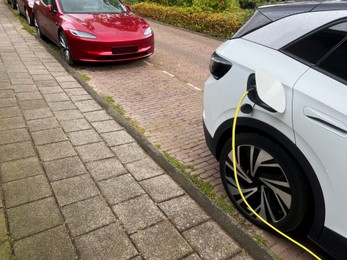 Photo of Modern electric car charging on city street